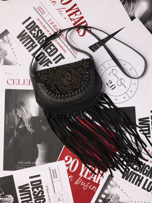 Black fringe handbag on a magazine with black and white text